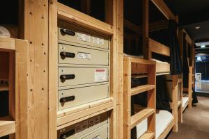 a row of bunk beds with drawers in a room at GuestHouse Hostel MangeTak ゲストハウス マングタック広島 in Hiroshima