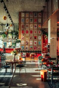 restauracja ze stołami i krzesłami oraz ścianą z obrazami w obiekcie JOST Hostel Montpellier Centre St Roch w Montpellier