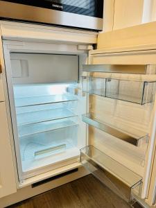 un réfrigérateur vide avec une porte ouverte dans l'établissement FeWo Kastanie mit Balkon, à Bad Harzburg