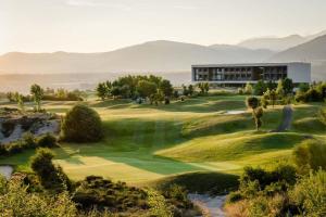 un campo da golf con un edificio sullo sfondo di Alojamiento ideal en Sabiñánigo a Sabiñánigo