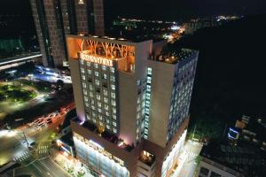 a tall building with a sign on it at night at Jeonju Signature Hotel in Jeonju