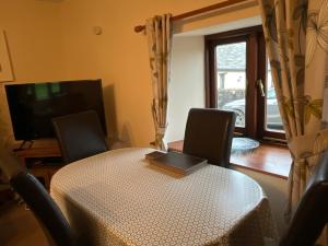 a dining room with a table with a laptop on it at Well Farm Cottages in North Tamerton