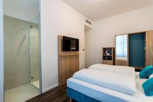 a bedroom with two beds and a glass shower at DaunTown Rooms - Self Check-In in Vienna