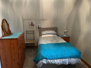 a small bedroom with a bed and a dresser at Well Farm Cottages in North Tamerton