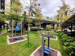 a park with swings and a playground in front of a building at Waterpark Ipoh Manhattan 3BR 8pax Condo Vacation Home by City Home Empire in Ipoh