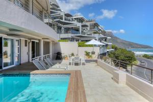 an apartment with a swimming pool and a building at Bakoven Sunsets - Luxury Apt with sea views & pool in Cape Town