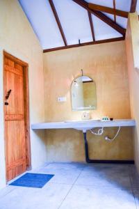 baño con lavabo y espejo en la pared en PEARL STAR BEACH RESORT, en Alankuda