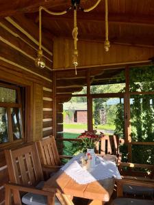 einen Holztisch und Stühle auf einer Veranda einer Hütte in der Unterkunft Wapienne domek in Sękowa