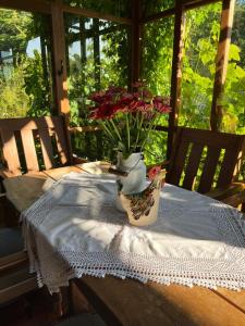 a table with a vase filled with flowers on it at Wapienne domek in Sękowa