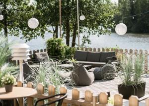 a patio with plants and tables and a couch at Hotel Waltikka in Valkeakoski