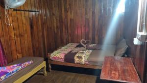 Habitación pequeña con cama y mesa en Hill Valley Farm House, en Nelliyampathy