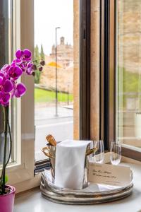 una mesa con un plato con una servilleta y copas de vino en Hotel Rector, en Salamanca