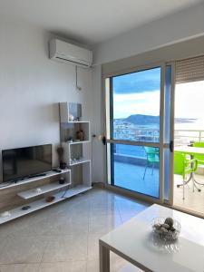 een woonkamer met een televisie en een tafel bij Deep Blue Sea View Apartments in Sarandë