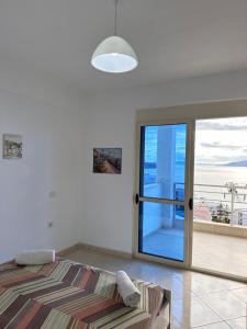 een slaapkamer met een bed en een glazen schuifdeur bij Deep Blue Sea View Apartments in Sarandë