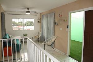 a living room with two chairs and a balcony at Casa grande de 4 niveles, cerca de Metrocentro in Santa Ana