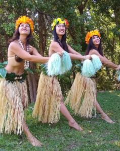three women in grass skirts with flowers on their heads at Camp NATURE in Bli Bli