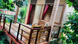 duas cadeiras sentadas na varanda de uma casa em Gibbon Singing Home Stay em Quan Tom