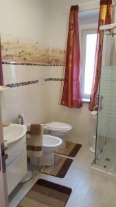a bathroom with a toilet and a sink and a shower at La casa del pescatore in Oliveri
