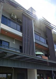 a building with a balcony with the sun shining on it at 宜蘭包棟民宿 嵐恬苑 歡唱 電動麻將 燒烤 in Yilan City