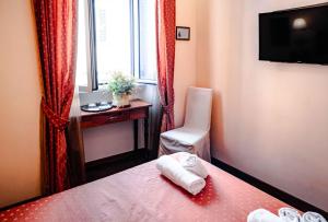 a hotel room with a bed and a chair and a window at Casa De' Fiori in Rome