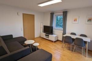 een woonkamer met een bank en een tafel bij NEU! Moderne Ferienwohnung Ulm in Ulm