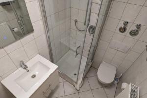 een badkamer met douche, toilet en wastafel bij NEU! Moderne Ferienwohnung Ulm in Ulm +1 foto