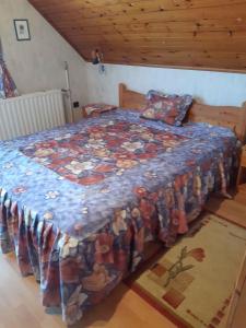 a bedroom with a bed with a blue comforter at Holiday home in Badacsonytomaj 20247 in Badacsonytomaj