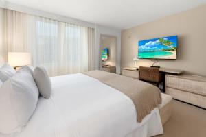 a bedroom with a large white bed and a desk at Oceanview Private Condo at 1 Hotel & Homes -1211 in Miami Beach