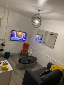 a living room with a couch and a table and a tv at appartement T2 porte de Pantin Métro Hoche in Le Pré-Saint-Gervais