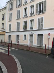 a large white building with windows and a street at appartement T2 porte de Pantin Métro Hoche in Le Pré-Saint-Gervais +8 photos