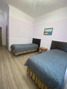 um quarto de hotel com duas camas e um sofá em Демалыс үйі Риза Гостевой дом em Vorobʼyëvka