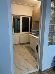 eine Küche mit einer Tür, die zu einem Zimmer mit einer Theke führt in der Unterkunft Vila Lumi in Constanţa