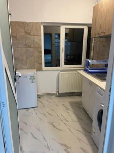 eine Küche mit Marmorboden und einem Kühlschrank in der Unterkunft Vila Lumi in Constanţa