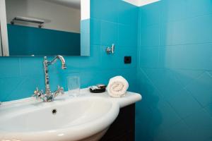 Baño azul con lavabo y espejo en SambaSS Boutique Apartment, en Capua