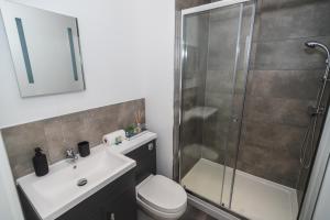 a bathroom with a shower and a sink and a toilet at VICHY - The Thornhill City Center Apartment in Wakefield