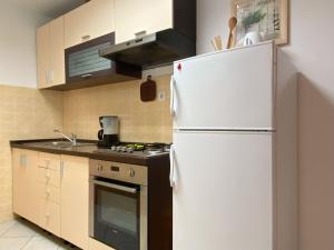 a kitchen with a white refrigerator and a stove at Apartment Ivan in Rovinj