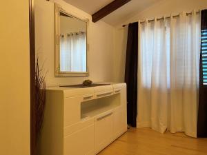 a bathroom with a mirror and a white dresser at Apartment Ivan in Rovinj