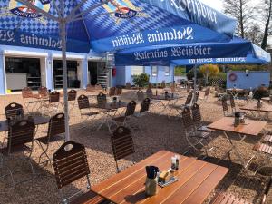 een patio met tafels, stoelen en parasols bij Birkenhof Family Lodge - a68755 in Rieschweiler-Mühlbach