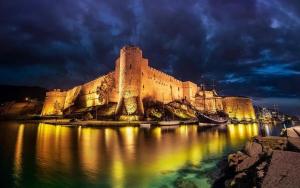 um grande castelo sentado na água à noite em ANADOL Hotel & Pool next to Kyrenia Harbour em Kyrenia