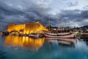 um grupo de barcos ancorados num porto com um castelo em ANADOL Hotel & Pool next to Kyrenia Harbour em Kyrenia