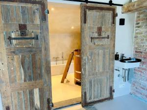 una antigua puerta de madera en un baño con lavabo en Sauna-Garden en Blankenberge