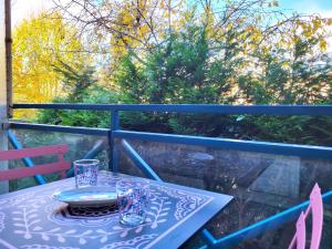 una mesa con un plato y gafas en el balcón en La Perla : F2 sans vis-à-vis, au pied du RER B, en Gif-sur-Yvette