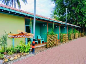 a green building with a sign in front of it at Kohmook​ Money​ House in Ko Mook