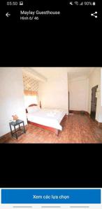 a picture of a bedroom with a bed and a table at Maylayguesthouse1 in Vang Vieng