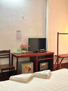 a bedroom with a bed and a television on a table at Maylayguesthouse1 in Vang Vieng