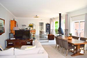 a living room with a white couch and a table at Riverclub Guest Suites in Riverclub, Sandton in Johannesburg