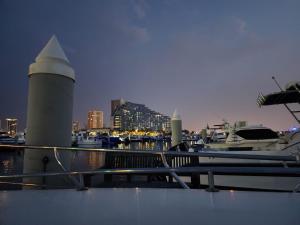 a dock with a lighthouse and boats in a harbor at A special 24 hours yacht stay in Manama
