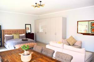 uma sala de estar com uma cama, um sofá e uma mesa em Riverclub Guest Suites in Riverclub, Sandton em Joanesburgo