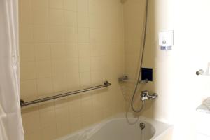 La salle de bains est pourvue d'une douche et d'une baignoire. dans l'établissement Hotel Gameiro, à Entroncamento