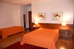 a hotel room with two beds and two lamps at Hotel Gameiro in Entroncamento